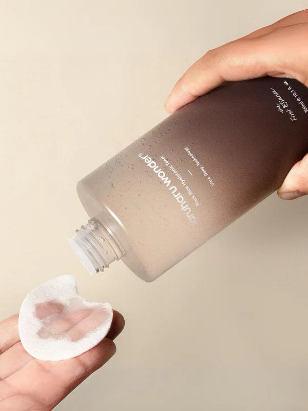 Haruharu Wonder Black Rice Hyaluronic Toner 300ml bottle pouring onto a cotton pad — EmartGCC Kuwait